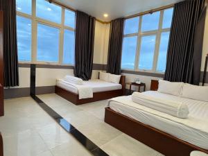 Bạc LiêuKhách sạn Vân Nhi的酒店客房设有两张床和大窗户