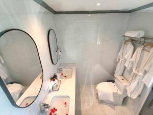 琅勃拉邦LuangPrabang Pearl Hotel的浴室设有镜子、盥洗盆和卫生间