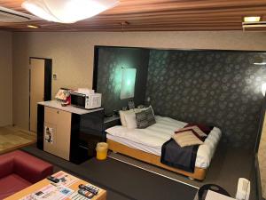 Minatomachiホテルアシュエル的一间小卧室,配有一张床和一台微波炉