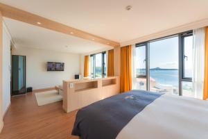 西归浦市Hotel Fine Jeju的一间卧室设有一张大床和一个大窗户