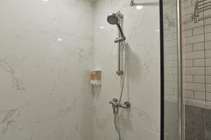 莱卡邦Grand BS Airport Hotel Suvarnabhumi的带淋浴的浴室,带玻璃门