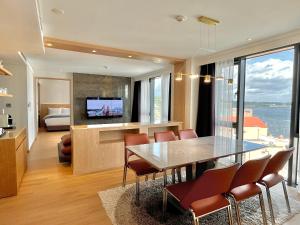 西归浦市Hotel Fine Jeju的用餐室以及带桌椅的起居室。