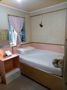 香港嘉湖旅館的一间小卧室,配有床和窗户