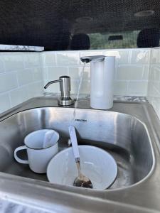 HauulaHW Campervan Rental NO CAMPGROUND的水槽里放着碗和勺子