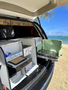 HauulaHW Campervan Rental NO CAMPGROUND的海滩上敞开的汽车干线