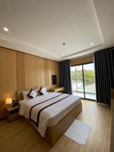 Tuy PhongKhách sạn - Nhà hàng Hoàng Phúc的一间卧室设有一张大床和一个大窗户