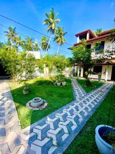 卡图纳耶克Dinu Lanka Resort的后院,有石头路和房子