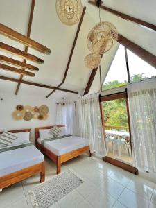 圣胡安Casa Maria at Bigang Munti的一间卧室设有两张床和大窗户