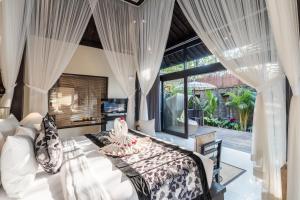 乌布The Kayon Valley Resort的一间卧室设有一张床和一个大窗户