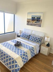 悉尼Lovely 2 bedroom apartment with city views的一间卧室配有一张带蓝色和白色棉被的床