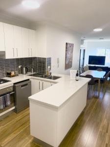 悉尼Lovely 2 bedroom apartment with city views的厨房配有白色橱柜和白色台面