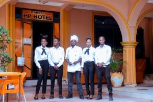 姆万扎Port Park Hotel的一群有联系的男人站在酒店前