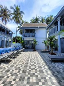 琅勃拉邦LuangPrabang Pearl Hotel的一个带长椅和棕榈树的庭院