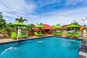 蓝梦岛Taman Sari Villa, Nusa Lembongan的一个带绿色椅子和遮阳伞的游泳池