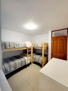 伊察Departamento familiar en Huacachina的带两张双层床和一扇门的房间
