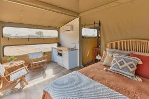 BroadwaterWillow Wood Glamping Retreat的一间设有床铺的卧室和帐篷内的厨房