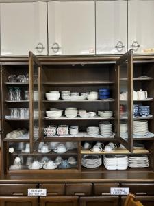 忍野村福寿苑　Fukujuen的装满盘子、碗和盘子的橱柜