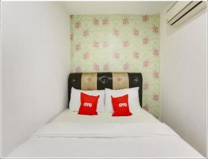 马六甲NS INN Hotel的一张带两个红色枕头的床