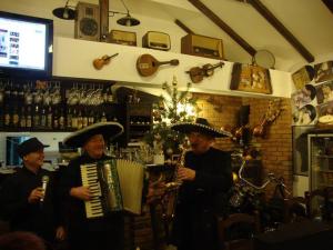 察赫劳Pensiunea TOTAL din Ceahlău的三个戴帽子的人在酒吧里演奏乐器
