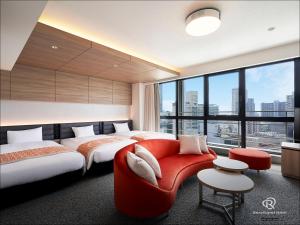 神户Daiwa Roynet Hotel KOBE-SANNOMIYA PREMIER的酒店客房带两张床和一张红色沙发