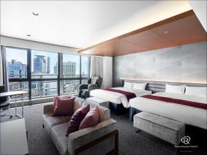 神户Daiwa Roynet Hotel KOBE-SANNOMIYA PREMIER的酒店客房,设有两张床和一张沙发