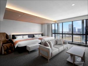 神户Daiwa Roynet Hotel KOBE-SANNOMIYA PREMIER的酒店客房,配有床和沙发