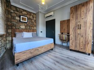 安塔利亚Sera Homes Kaleici Oldtown的一间卧室设有一张床和石墙