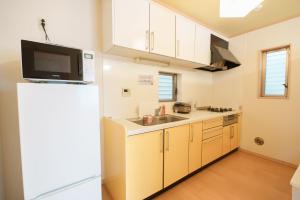 东京匯家•平和島ビル的厨房配有冰箱和水槽