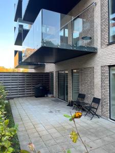 奥尔堡Charming Aalborg Apartment With parking的一座带两把椅子的庭院和一座位于大楼内的阳台