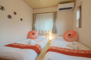 东京匯家•平和島ビル的一间卧室配有两张床,拥有橙色的装饰