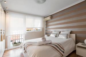 马德里Chalet independiente de diseño con Patio Privado的一间卧室设有一张带条纹墙的大床