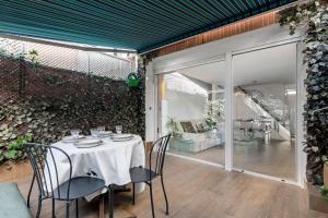 马德里Chalet independiente de diseño con Patio Privado的一间带桌椅的用餐室