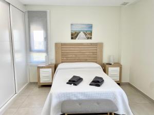 卡内拉岛OCEAN HOMES, Apartamentos exclusivos en Isla Canela - By AC REAL的一间卧室配有一张床,上面有两条毛巾