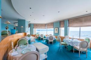 沼津Awashima Hotel的一间设有桌椅的海洋餐厅