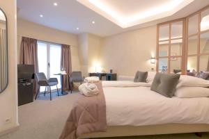 克诺克－海斯特卢加诺酒店的卧室配有一张白色大床和一张书桌