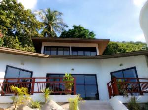 帕干岛Sojourn 6 bedroom villa near Full Moon Beach的前面有楼梯的房子