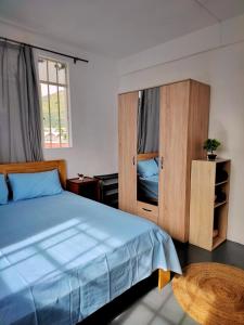 路易港Port Louis Centre penthouse的一间卧室配有一张蓝色的床和木制橱柜。