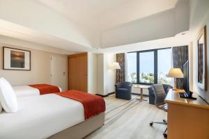 马斯喀特马斯喀特皇冠假日酒店的配有一张床和一张书桌的酒店客房