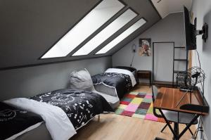 KrompachyBoutique apartmán的阁楼卧室设有两张床和天窗