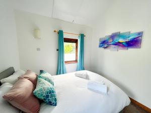 约尔Seascape Bliss - Coastal Retreat in Youghal`s heart - Family Friendly - Long Term Price Cuts的卧室配有白色的床和窗户。