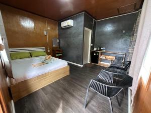 库德岛Suan Nai Kokut Resort的一间小卧室,配有一张床和两把椅子