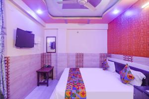 坎普尔FabExpress Kanha Dham的一间卧室配有一张床和一台平面电视