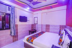 坎普尔FabExpress Kanha Dham的一间卧室配有一张床和一台电视。