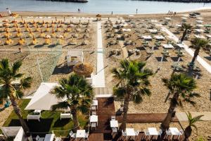 里米尼巴尔迪尼尼酒店的享有海滩的空中景致,配有椅子和棕榈树