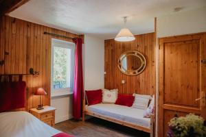 Saint-Jean-Saint-NicolasLES PRIMEVERES的一间卧室设有木墙,窗户设有长凳