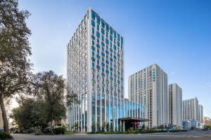 佳木斯Wanda Jin Jiamusi的一座高大的建筑,在城市里装有玻璃窗