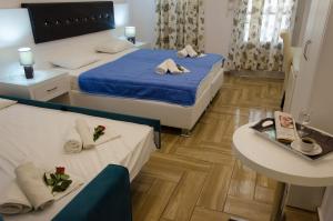斯基亚索斯镇珀丽卡提斯旅馆的酒店客房设有两张床和一张桌子。