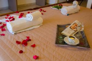 斯基亚索斯镇珀丽卡提斯旅馆的一张桌子,上面有毛巾,还有一杯咖啡和玫瑰