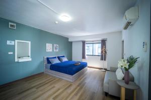 暖武里府Baansuay Rattanathibet Apartment的蓝色的卧室配有床和沙发