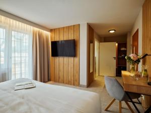 科沙林福尔德酒店的酒店客房配有一张床、一张书桌和一台电视。